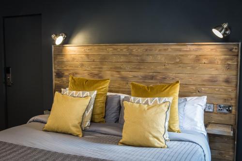 a bed with yellow pillows and a wooden headboard at Tipperary House Dublin in Dublin