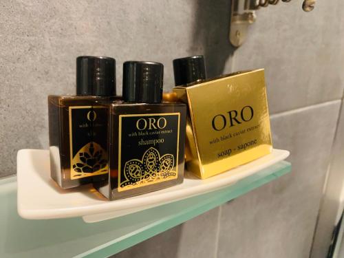 three bottles of oil on a shelf in a bathroom at Waterfront Lodge in Dunapataj