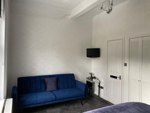 a blue couch in a living room with a tv at Ashburn House in Fort William