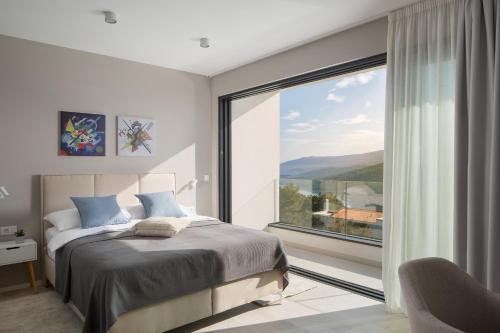 sypialnia z łóżkiem i dużym oknem w obiekcie Villa Selene w Rabacu