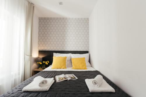 - une chambre dotée d'un lit avec des oreillers et des serviettes jaunes dans l'établissement Way2Stay Bosacka, à Cracovie