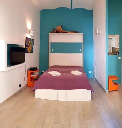 - une chambre avec un lit et une couverture violette dans l'établissement Studio centre ville, à Ajaccio