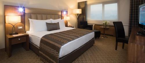 a hotel room with a bed and a television at Mövenpick Hotel Izmir in Izmir