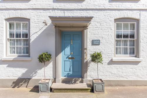 a blue door on a white building with two windows at Turford House, Ludlow in Ludlow