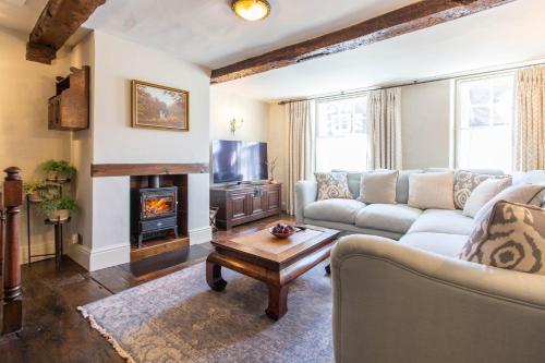 a living room with a couch and a fireplace at Turford House, Ludlow in Ludlow