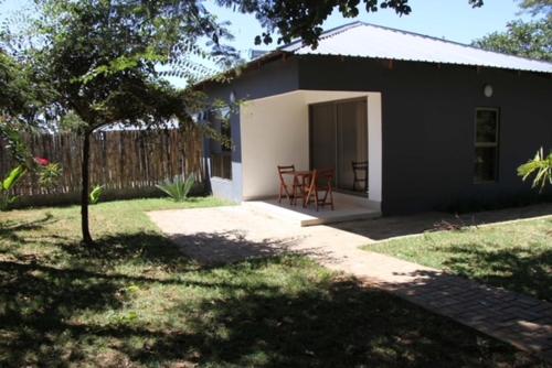 una pequeña casa con una mesa y sillas en un patio en !! The ranch - Superb serviced apartment with garden en Lusaka