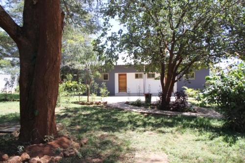 a house with trees in front of a yard at !! The ranch - Superb serviced apartment with garden in Lusaka