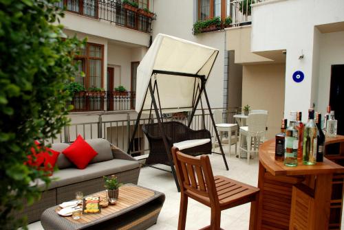 un patio con divano e tavolo sul balcone. di Dosso Dossi Hotels Old City a Istanbul