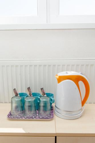 a tea kettle and cups on a table at Penzion Hviezda in Bratislava