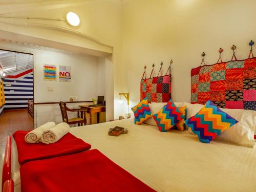 um quarto com uma cama grande e almofadas coloridas em goSTOPS Kochi em Cochin