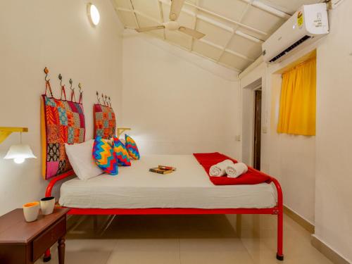 a bedroom with a red and white bed in a room at goSTOPS Lite Kochi in Cochin
