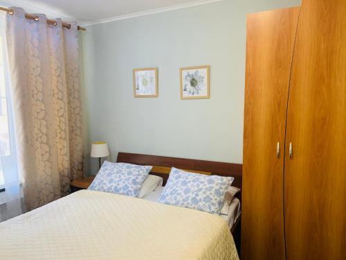 a bedroom with a bed and a wooden cabinet at Oksana's Apartments - Nevsky 64 in Saint Petersburg