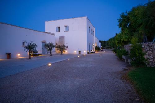 a white building with lights on the side of it at Masseria Montelauro in Otranto