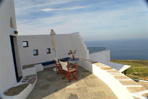a table and chairs on the balcony of a building at Windmill Villas in Artemonas