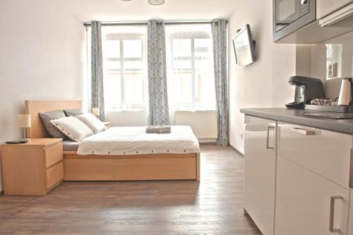 um pequeno quarto com uma cama em frente a uma janela em R&J apartmány em Broumov