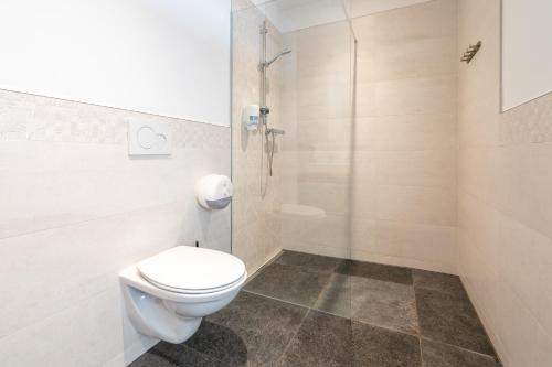 a bathroom with a toilet and a glass shower at Kaiser Max Design Appartements in Innsbruck