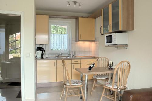 a kitchen with a table and chairs and a microwave at Modernes 5-Sterne-Ferienhaus im Maisonettenstil in DAMP in Damp