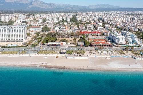 eine Luftansicht auf einen Strand mit Gebäuden und das Meer in der Unterkunft Sare Beach Hotel in Antalya