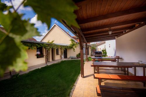 a patio with a table and benches and a house at Penzion Marhulka in Dolní Věstonice