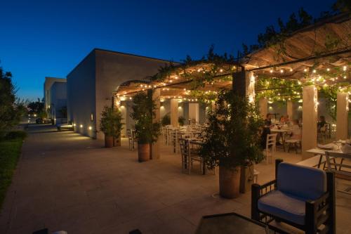 a patio with tables and chairs and lights at night at Masseria Montelauro in Otranto
