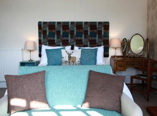 a bedroom with a bed with a blue comforter at Furain in Peterculter