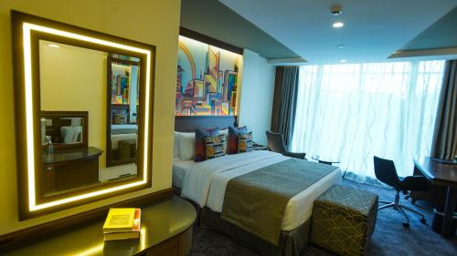 a hotel room with a bed and a mirror at Sarova Panafric Hotel in Nairobi