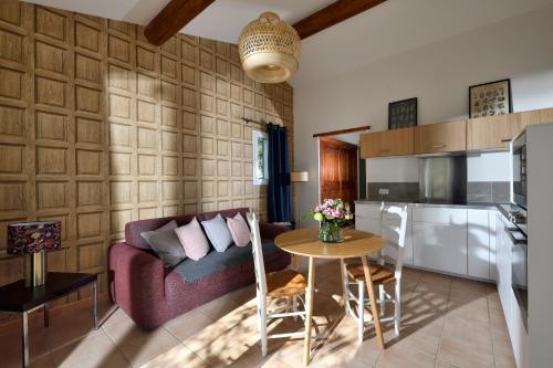 ein Wohnzimmer mit einem Sofa und einem Tisch in der Unterkunft Les Mazets de Marie de Jules in Eyragues