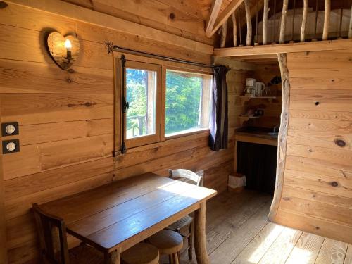 - une table en bois dans une chambre avec fenêtre dans l'établissement Domaine de Campras B&B, à Saissac