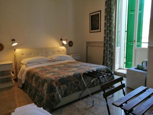 een slaapkamer met een bed, een stoel en een raam bij Borgoanticoview in Bari