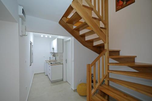 een houten trap in een kamer met een keuken bij Studio apartments Kalma in Dubrovnik