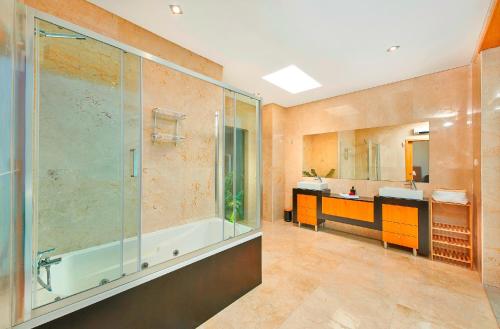 La salle de bains est pourvue d'une douche, d'un lavabo et d'une baignoire. dans l'établissement Stunning Townhouse With Pool In Tavira Centre, à Tavira