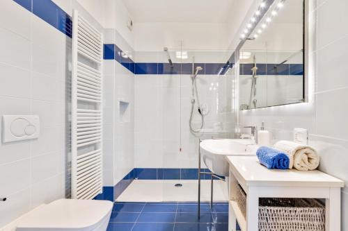 コモにあるLa Perlaの青と白のタイル張りのバスルーム(シャワー付)