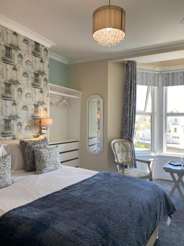 a bedroom with a large bed with a blue blanket at St Johns Guest House in Weymouth