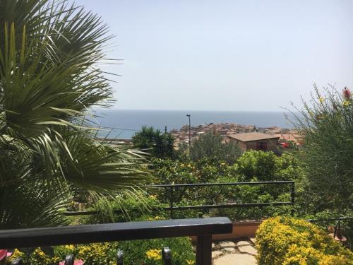 a bench in a garden with the ocean in the background at Villa Stefania in Marina di Camerota