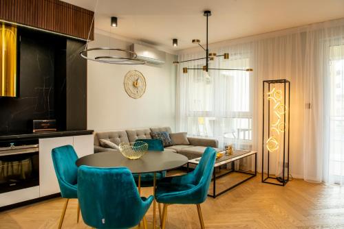 salon ze stołem i niebieskimi krzesłami w obiekcie Apartament Gold - Racławickie 28a w mieście Lublin