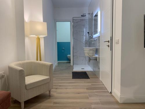 a living room with a chair and a bathroom at Sa Conca holiday in Cagliari