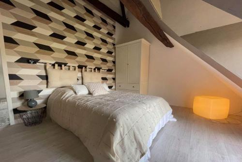 - une chambre avec un lit et un mur en damier dans l'établissement Les sureaux du cher, à Noyers-sur-Cher