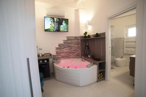 Habitación con baño con bañera rosa. en Residenza Montegrappa en Peschici