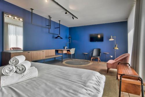 a blue bedroom with a bed and a desk at Guest House de la Valette in Valletta