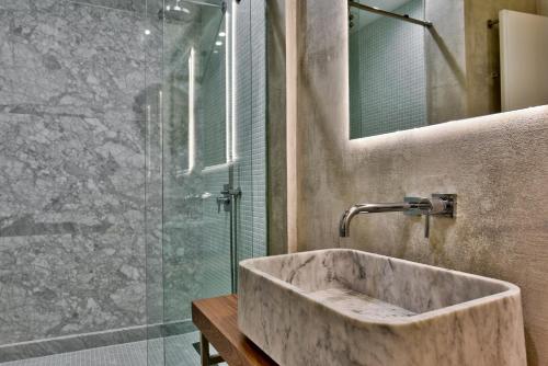 a bathroom with a stone sink and a shower at Guest House de la Valette in Valletta
