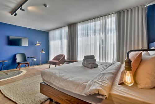 a bedroom with a large bed with blue walls at Guest House de la Valette in Valletta