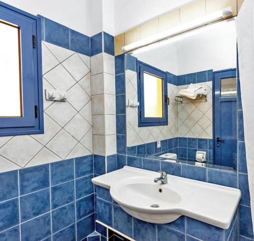 a blue tiled bathroom with a sink and a mirror at Ionian Sea View Hotel - Corfu in Kavos