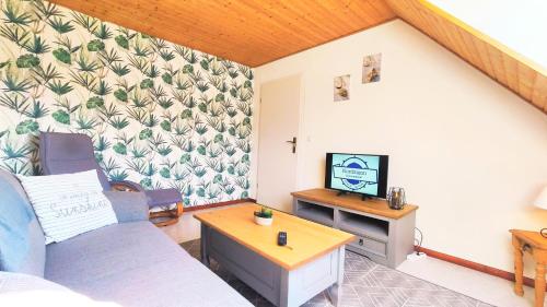 a living room with a couch and a tv at Gästehaus Zur alten Post in Dornumersiel