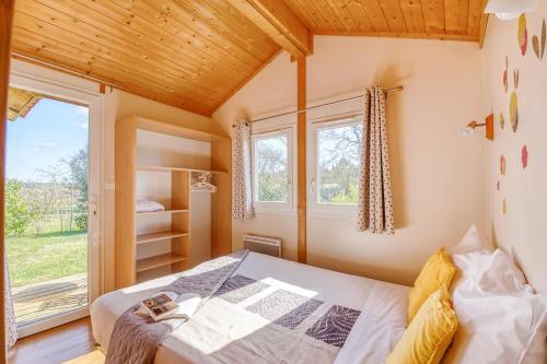 une petite chambre avec un lit et une fenêtre dans l'établissement Domaine des Cadets de Gascogne, à Pauilhac