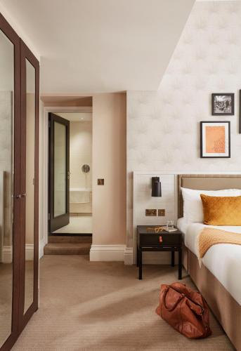 a hotel room with a bed and a bathroom at The Clermont London, Victoria in London