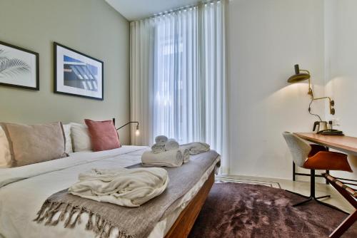 a bedroom with a bed with a desk and a window at Guest House de la Valette in Valletta