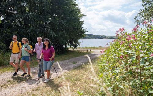 a group of people walking on a path by the water at DER SCHWAN Hotel & Restaurant in Schwanstetten