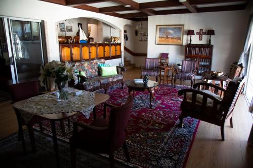 - un salon avec un canapé, des tables et des chaises dans l'établissement Place des Amoureux - No loadshedding, à Plettenberg Bay