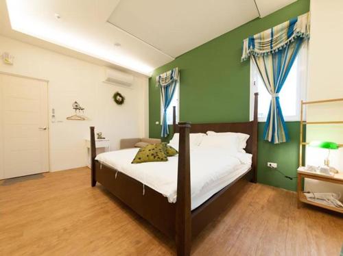 - une chambre dotée d'un lit avec un mur vert dans l'établissement Mu river Villa 慕河包棟休閒別墅, à Wujie