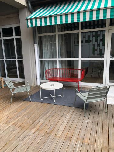 a patio with two chairs and a table on a deck at Ibis Saint Étienne - La Terrasse in Saint-Étienne